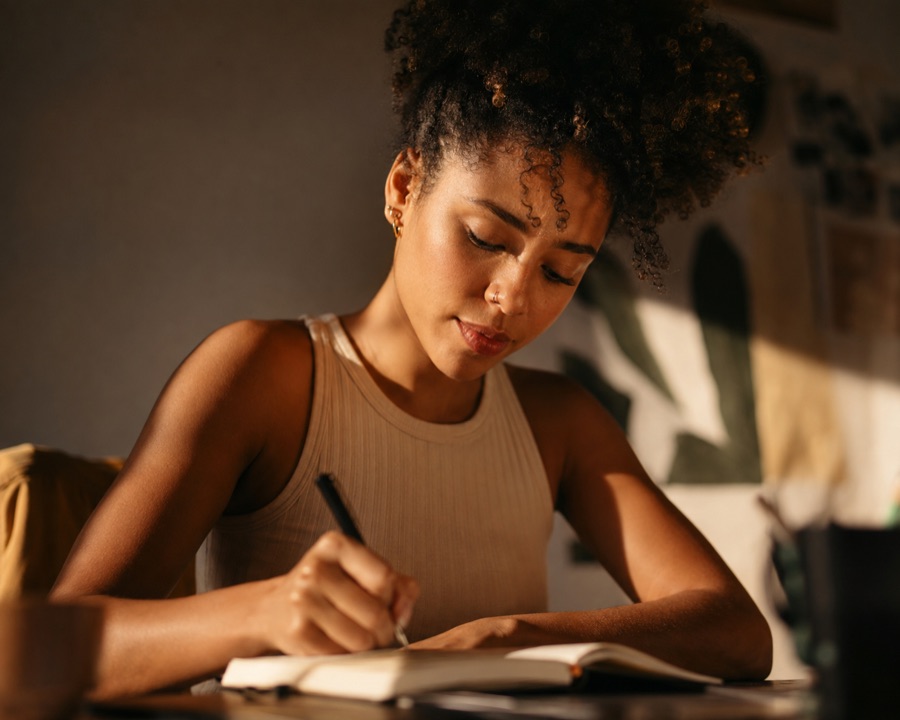 Aluna da FIA digital estudando com um caderno